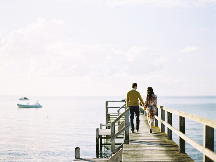 engaged couple walking on jetty in morning ton peninsula