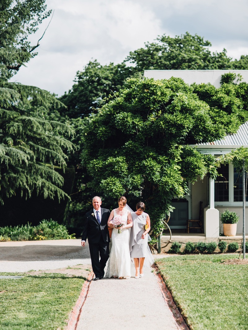 bride waling down the aisle with mum and dad wedding