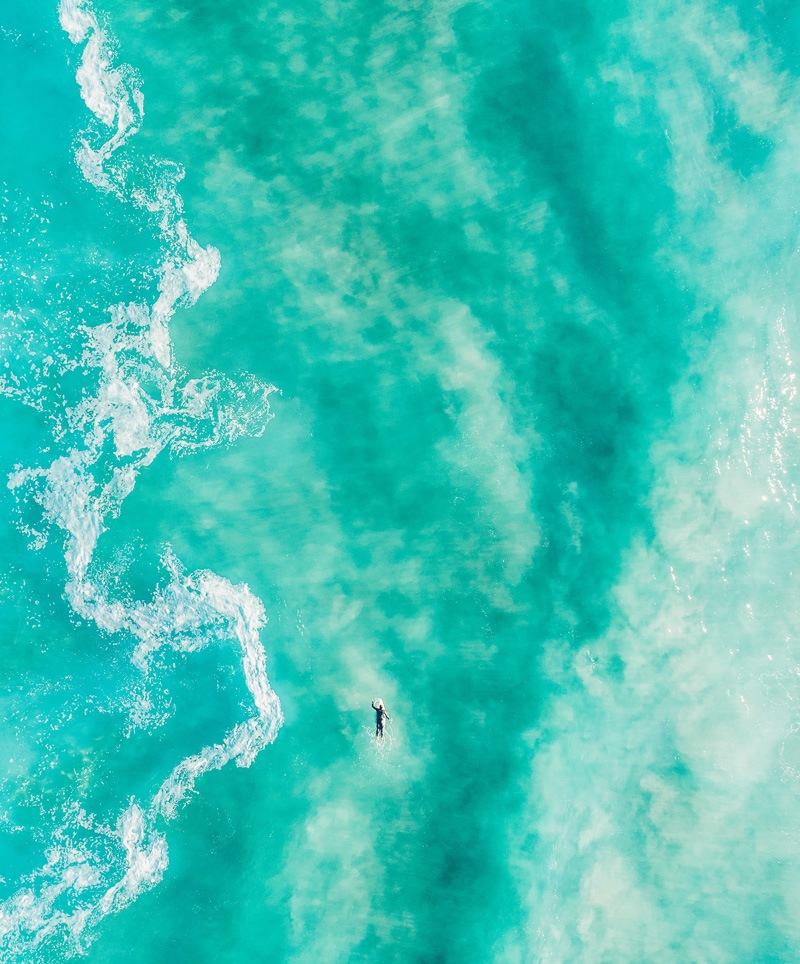 surfer paddling out to the back of the waves