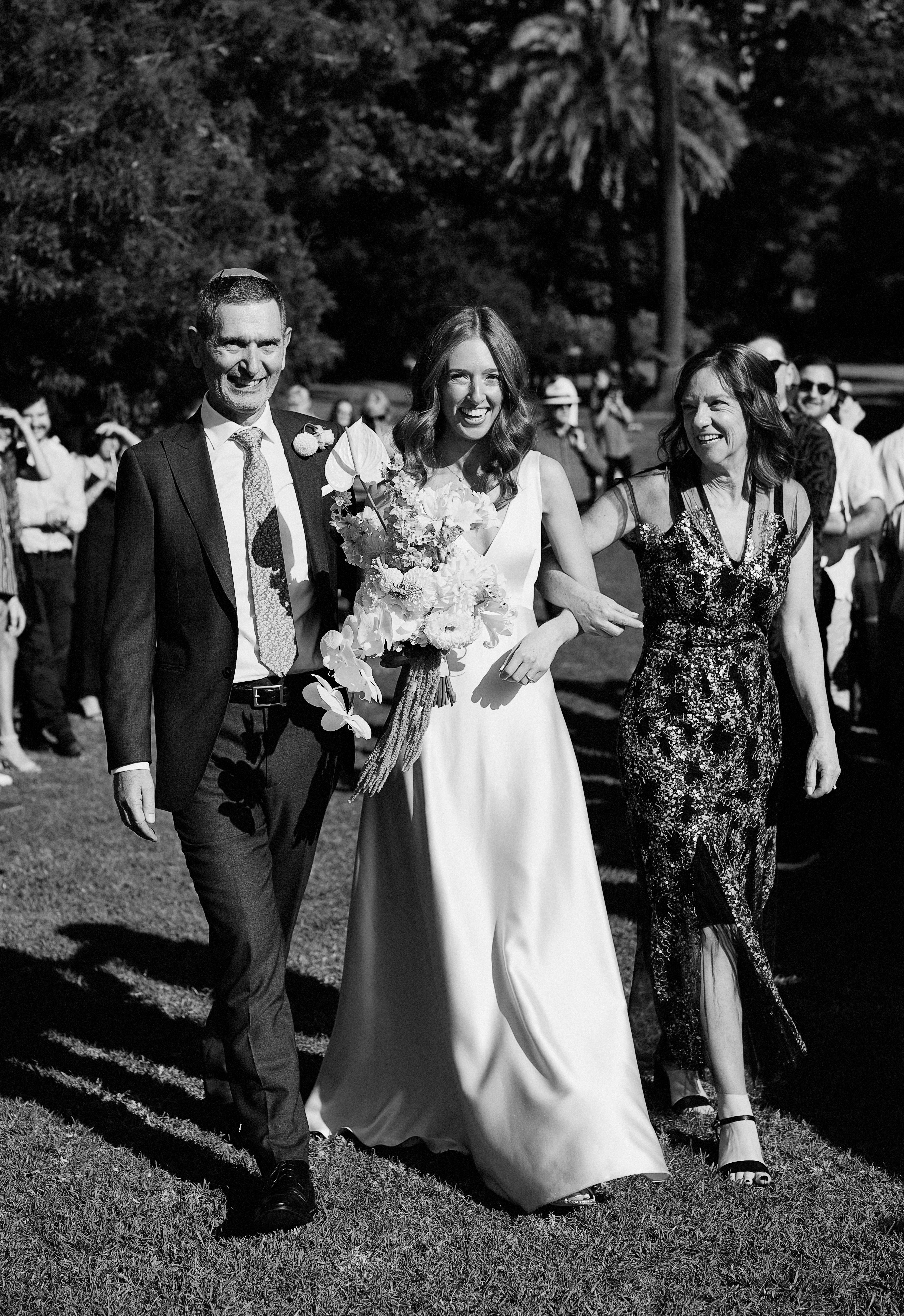 bride walking down the aisle with parents 